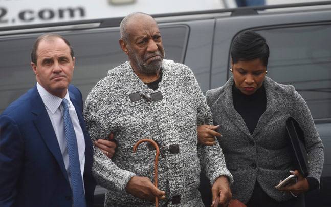 Bill Cosby walking with his lawyers