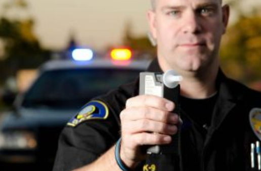 Close-up view of a police officer holding a breathalyzer